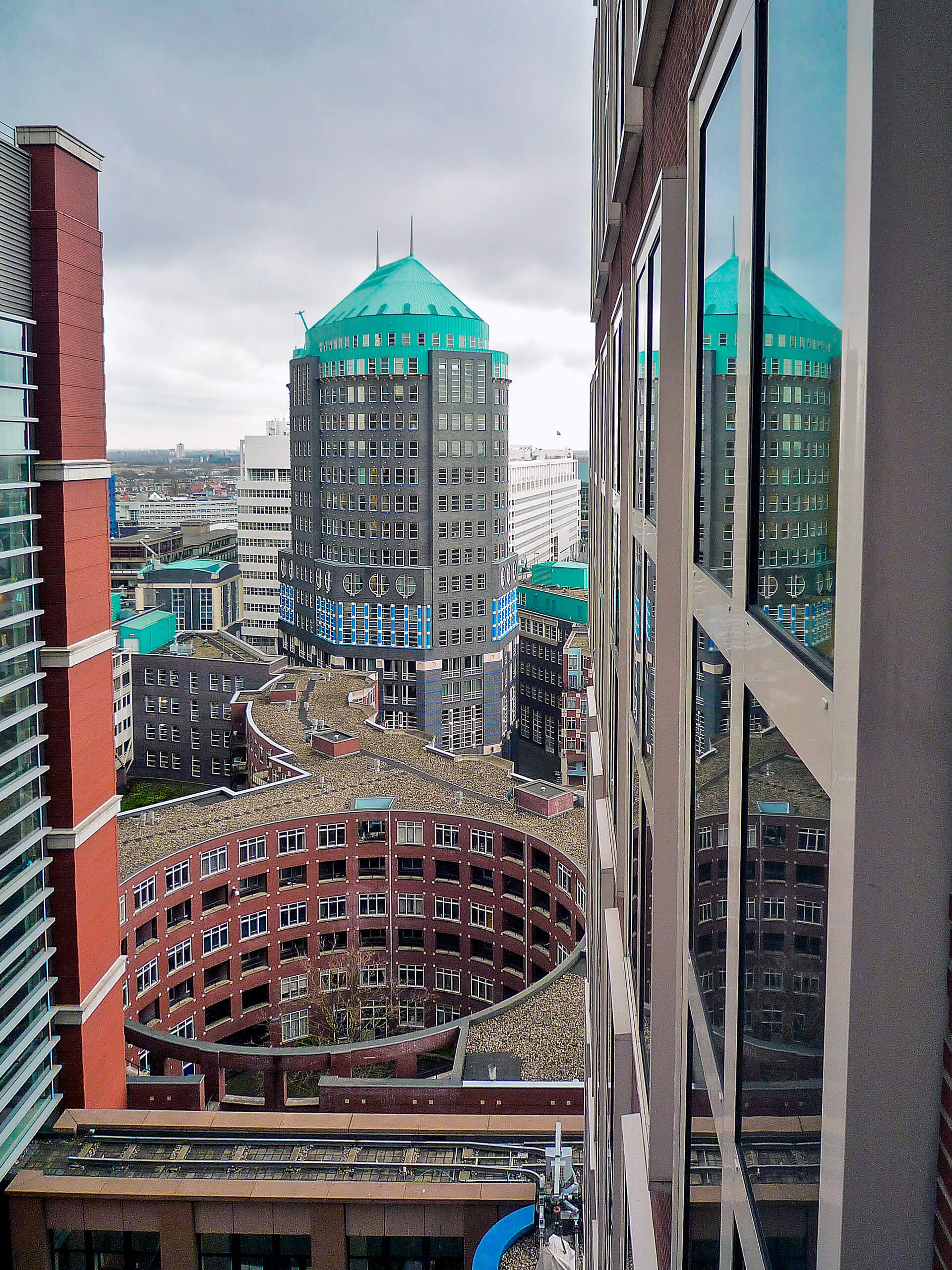 Aufnahme aus dem Gebäude Castalia des niederländischen Gesundheitsministeriums. Im Zentrum: der Muzentoren mit dem „Eispalast“ (Rathaus Den Haag) im Hintergrund. Die Aufnahme gehört zur Seite über die Erstellung von Websites in Den Haag.